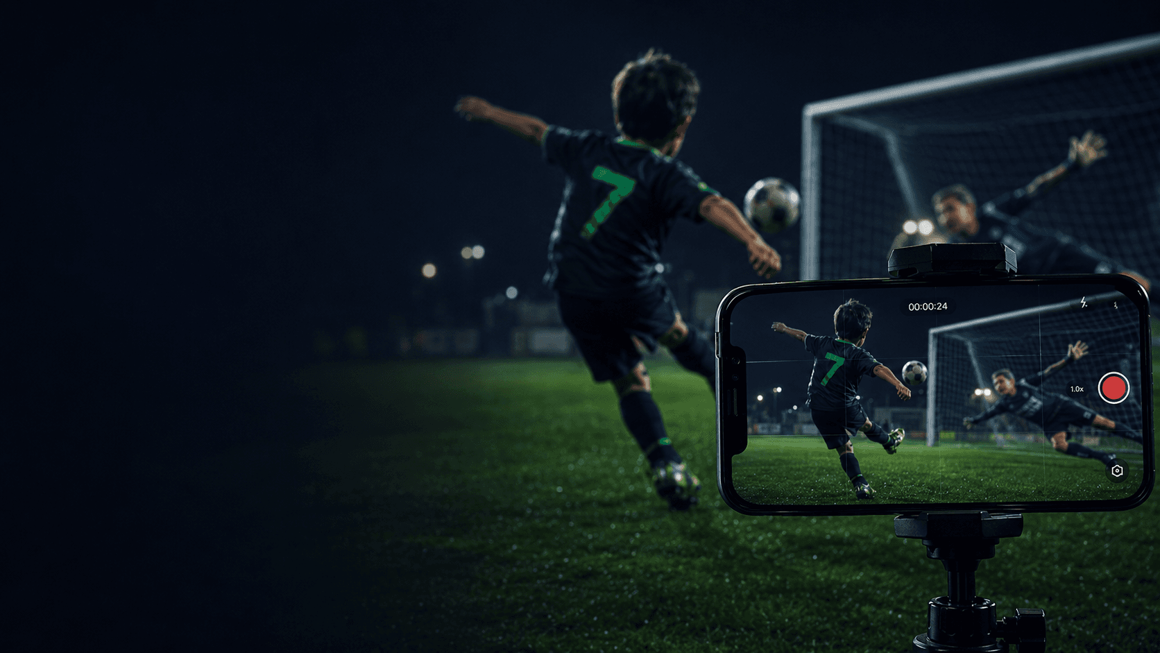 Criança de camisa 7 finalizando a gol num campo à noite